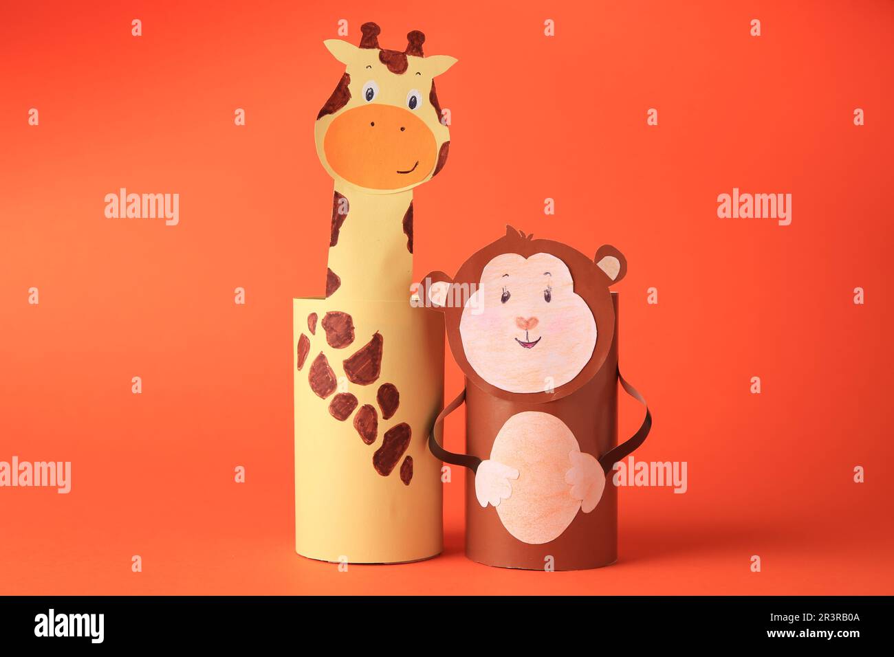 Toy monkey and giraffe made from toilet paper hubs on orange background. Children's handmade ideas Stock Photo