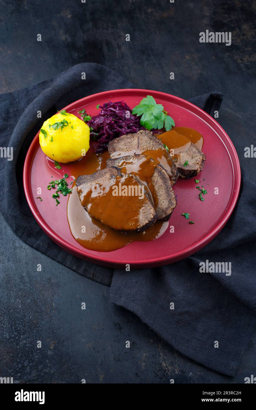 Traditional braised marinated German Sauerbraten from beef with blue