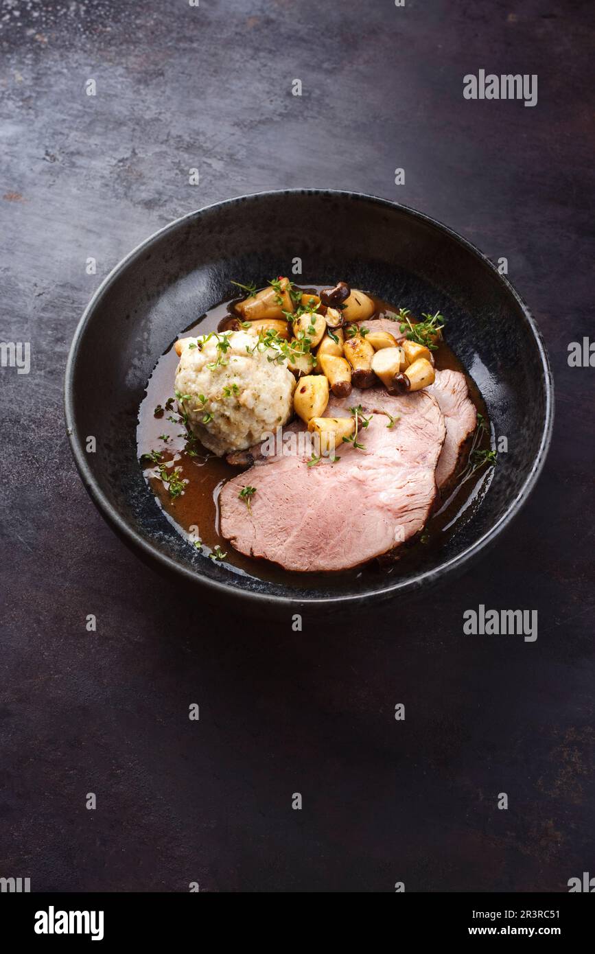 Traditional German pork roast served with bread dumpling and king