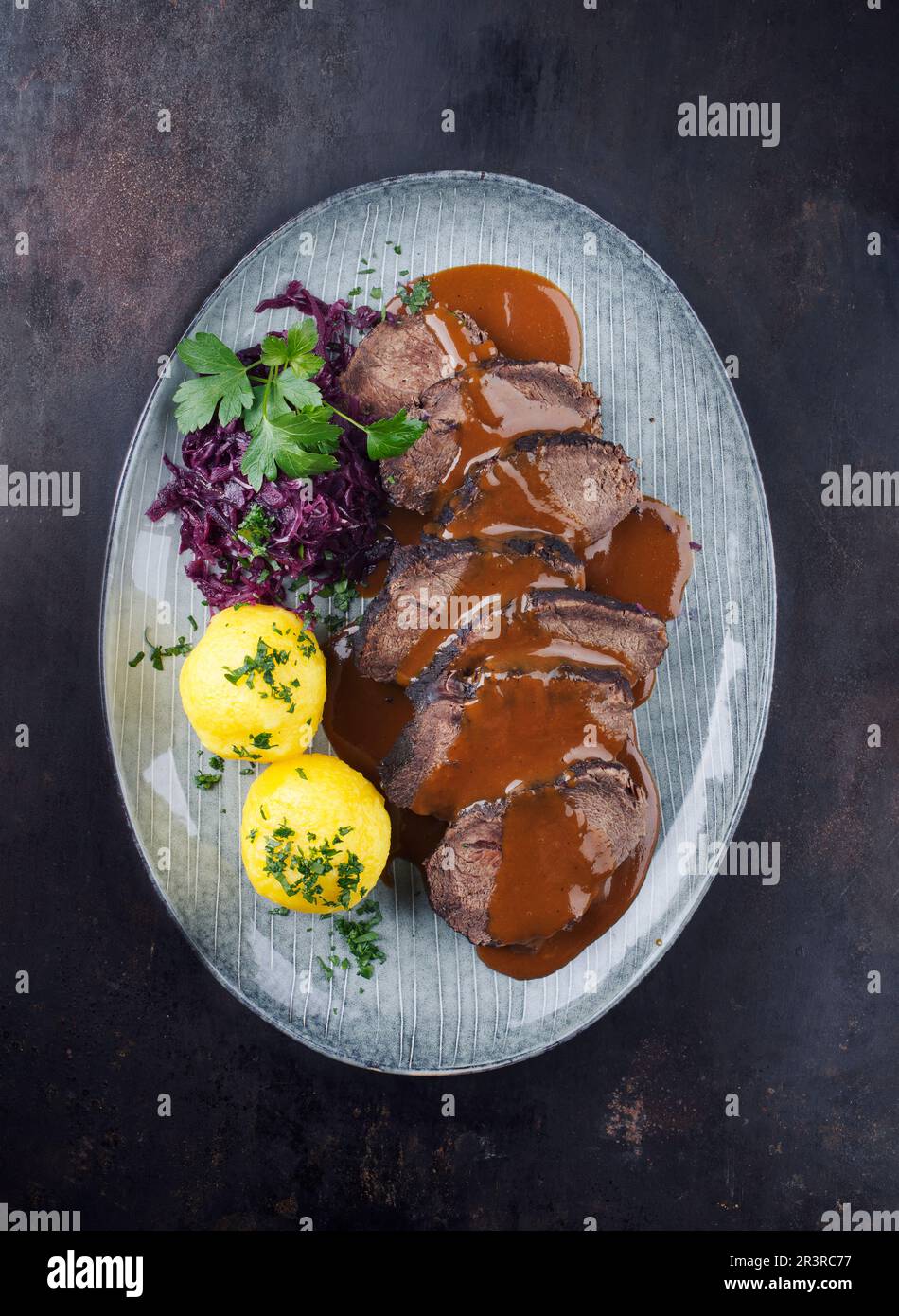 Traditional braised marinated German Sauerbraten from beef with blue