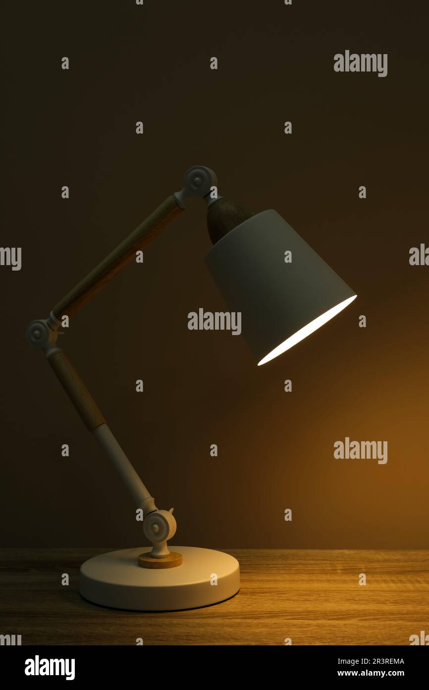 Stylish modern desk lamp on wooden table at night Stock Photo