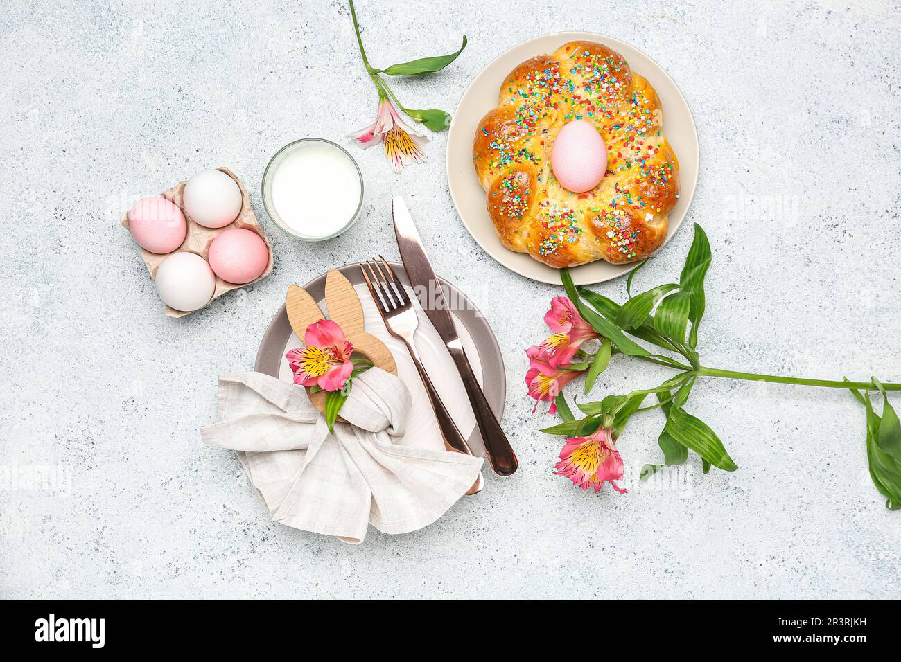 Table setting with tasty Italian Easter bread, eggs, glass of milk and  flowers on light background Stock Photo - Alamy