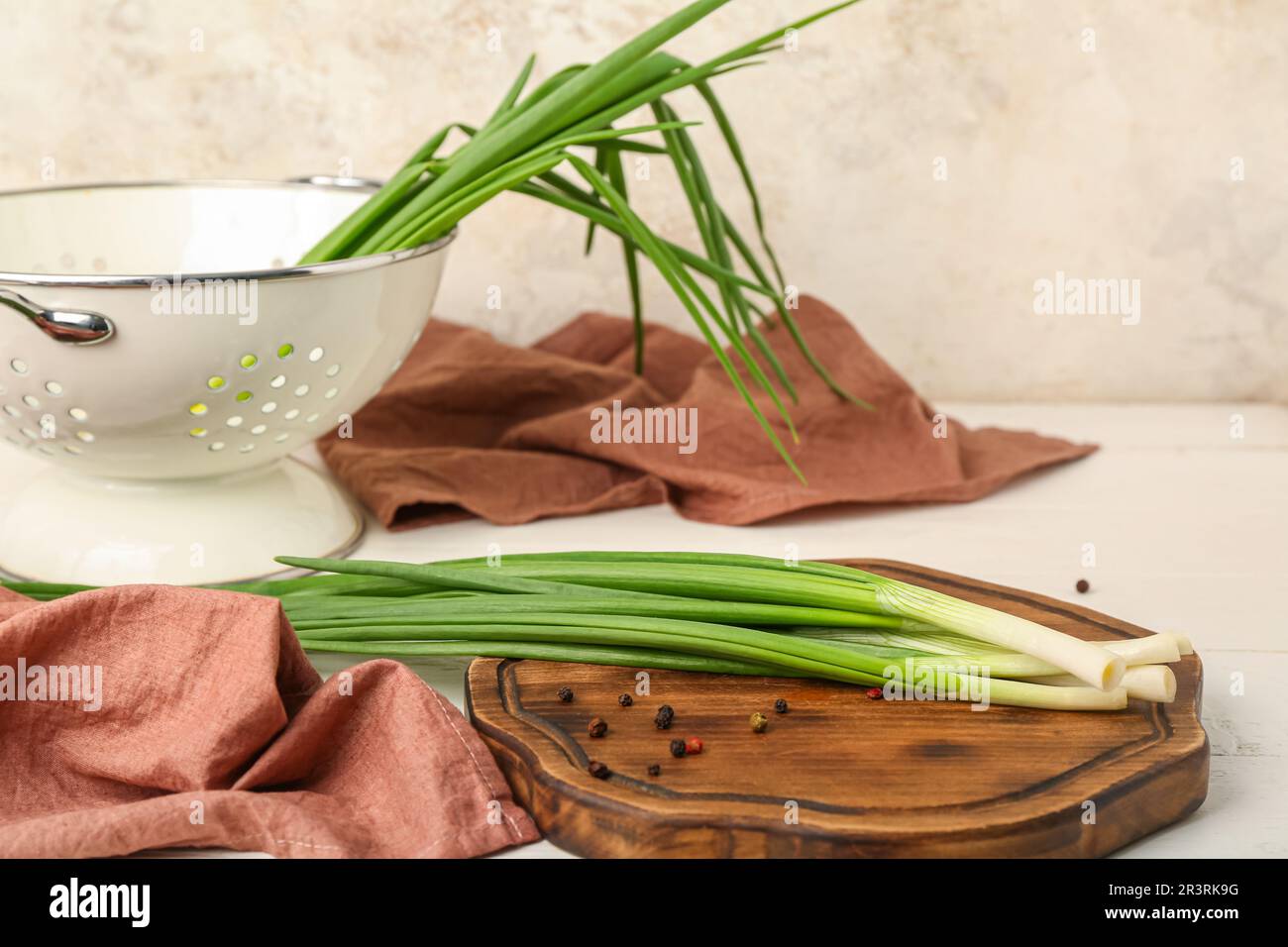 Wooden board with fresh green onion on light background Stock Photo - Alamy