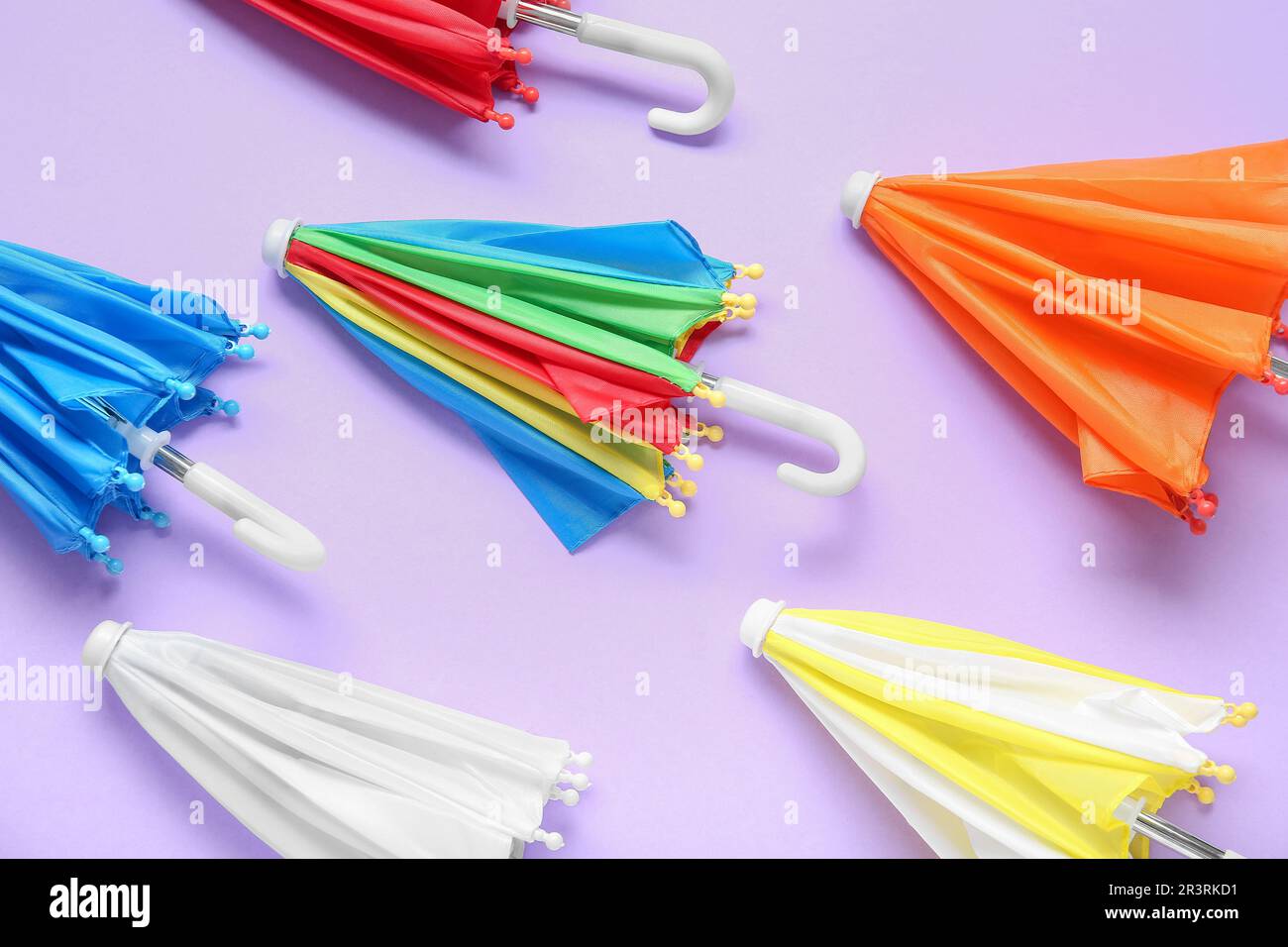 Many different umbrellas on lilac background Stock Photo
