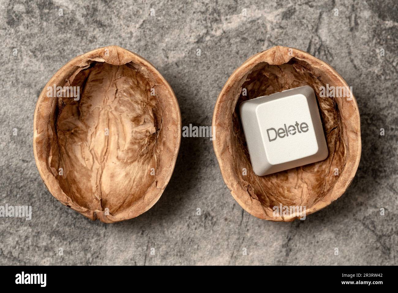 Opened walnut shell with a DELETE key of computer keyboard Stock Photo