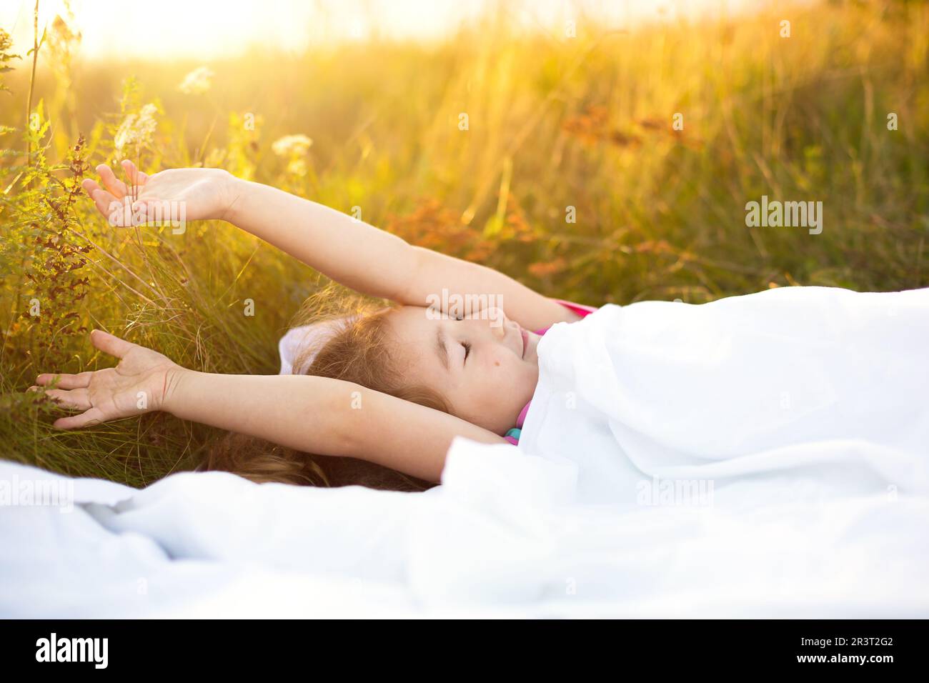 Girl sleeps on bed in grass, Sweet stretches and yawns sleepily, good