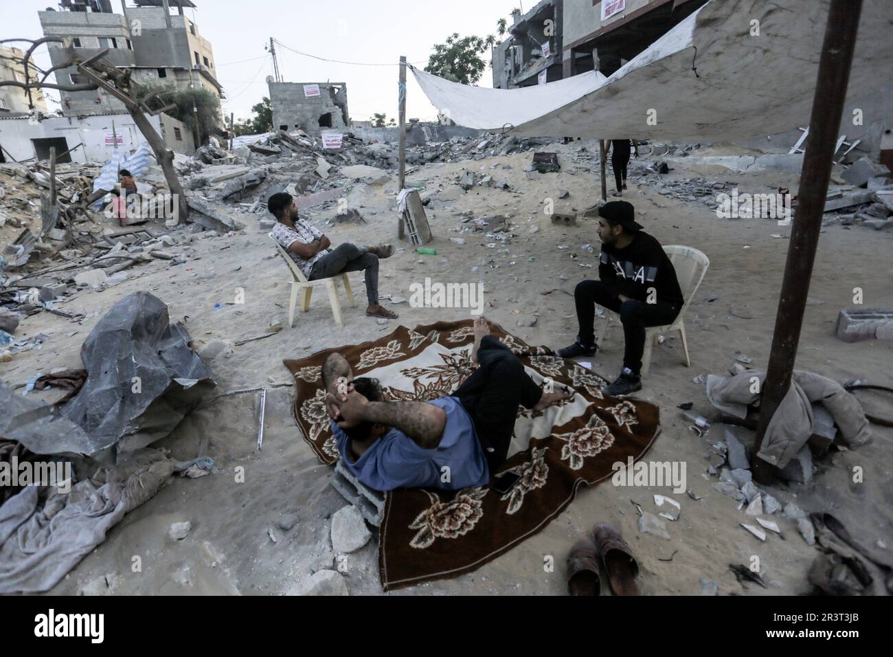 Gaza, Palestine. 24th May, 2023. Palestinians sit amidst the rubble of ...