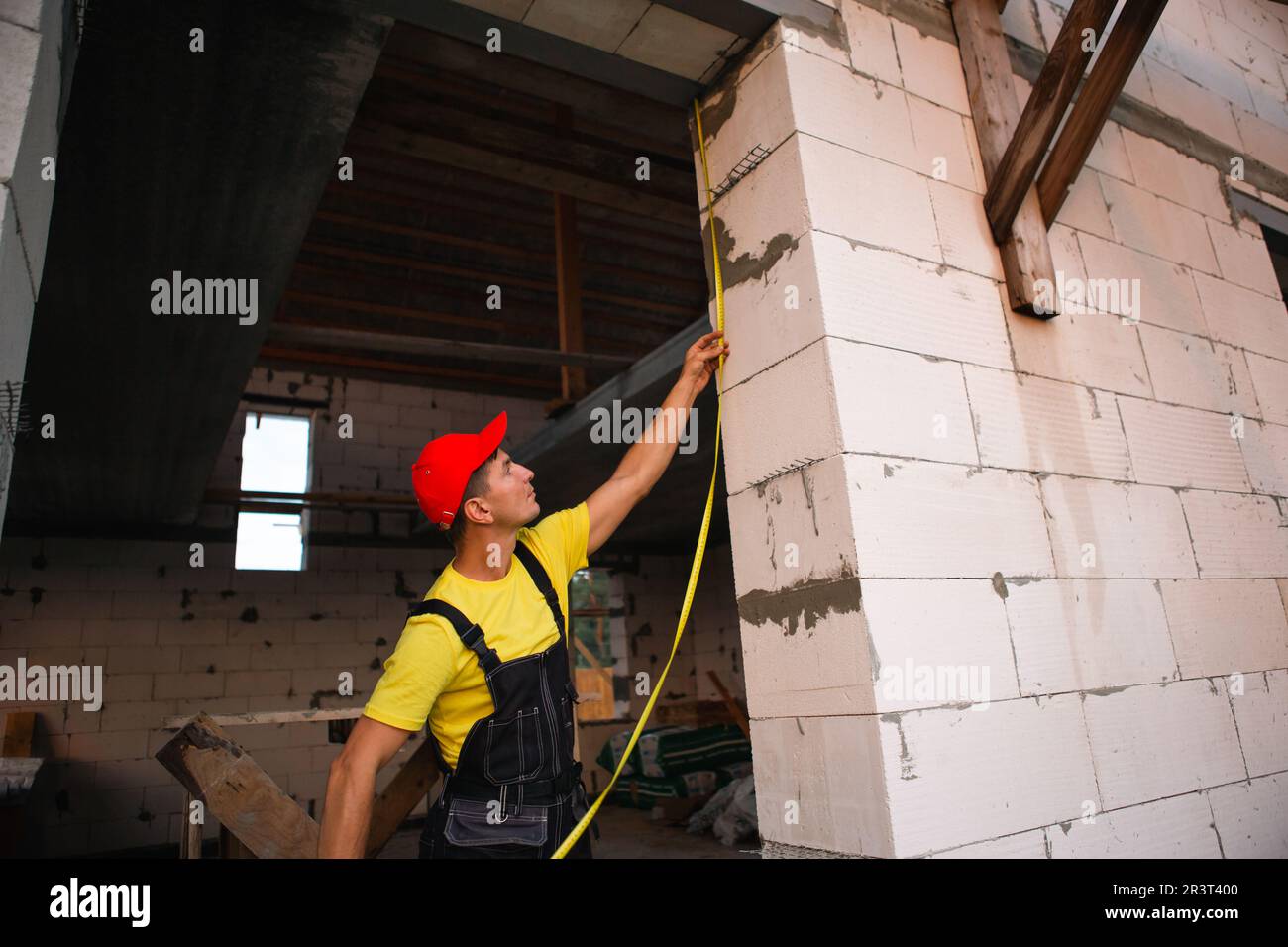 Construction worker at construction site measures the length of window