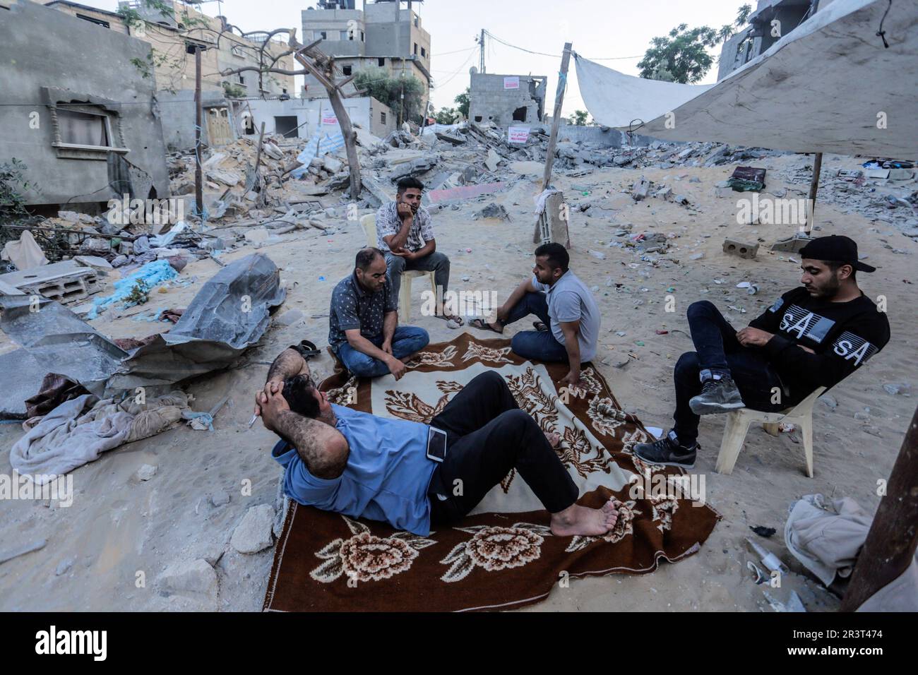 Gaza, Palestine. 24th May, 2023. Palestinians sit amidst the rubble of ...