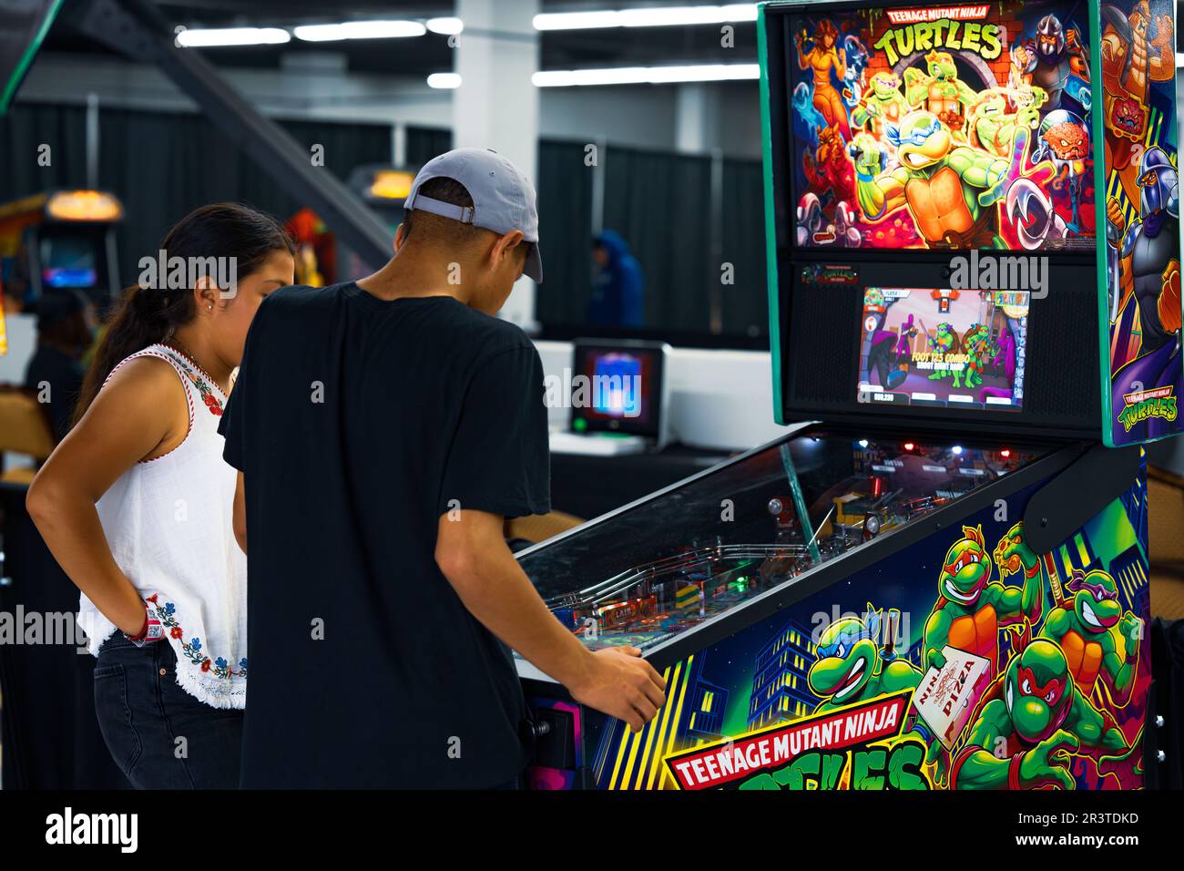 Couple play Teenage Mutant Ninja Turtles pinball machine at the Los