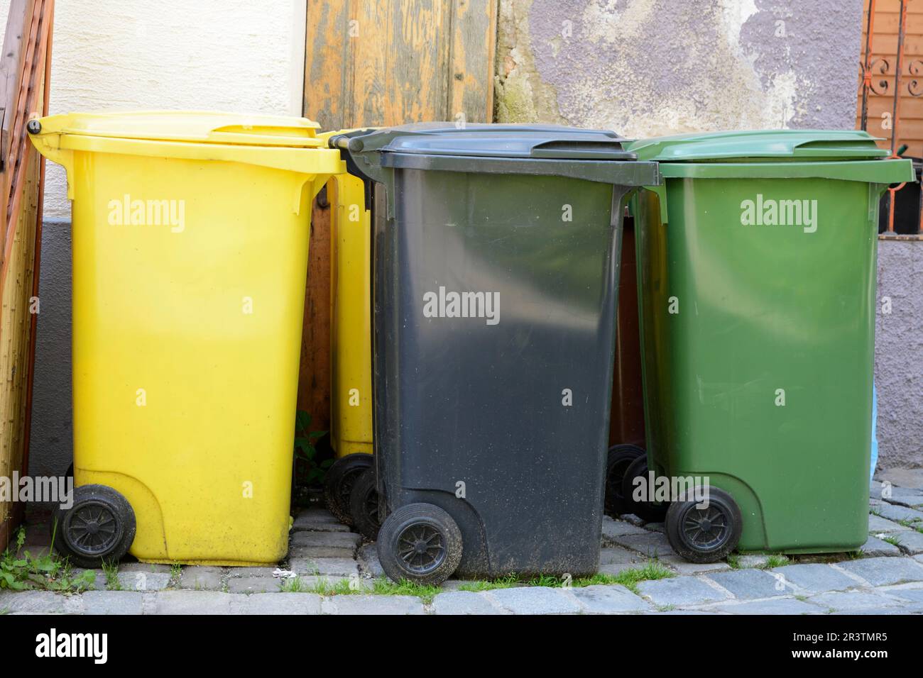 Three garbage cans in different colors for waste separation Stock Photo