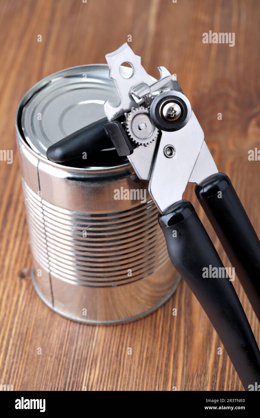 Old style tin opener opening a can, isolated on white background Stock  Photo - Alamy