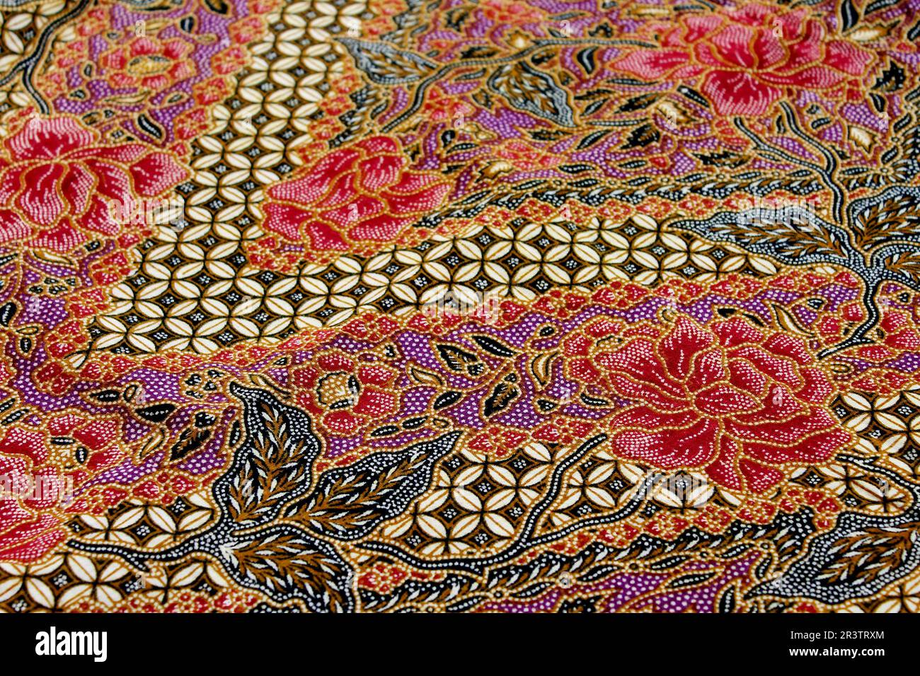 Batik fabrics are Indonesian textiles made using wax-resist dyeing. They feature intricate patterns and vibrant colors, holding cultural significance Stock Photo