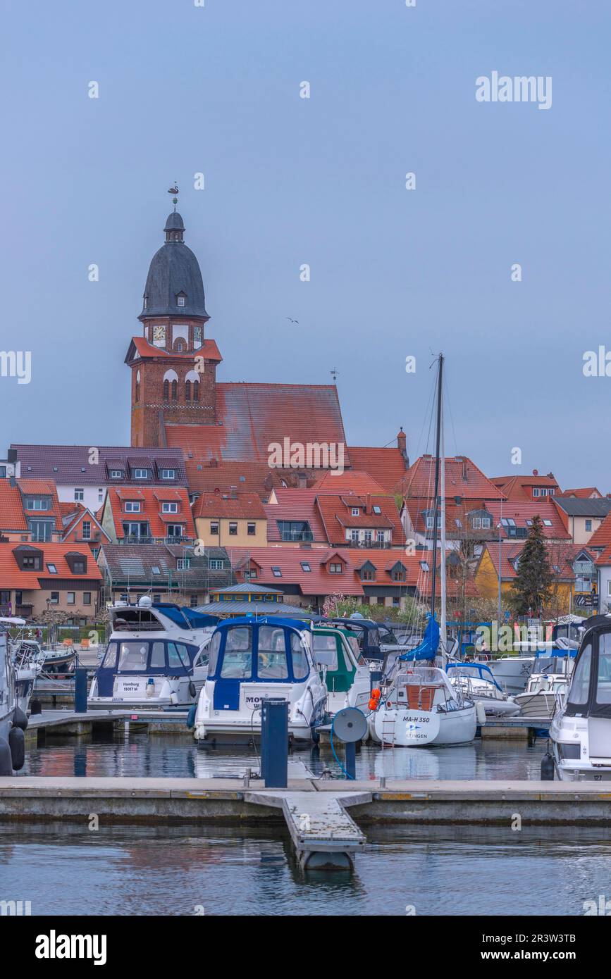 City harbour with motor boats, Waren, St. George's Church, evening light, sky, old town, renovation, portrait format, Mecklemburg Lake District Stock Photo