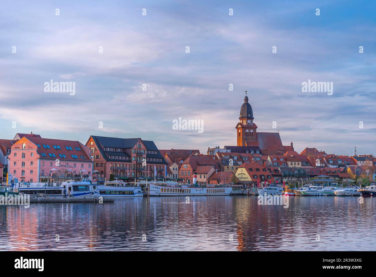 City harbour with motor boats, Waren, St. Georgen church, evening light, sky, water reflection, old town, redevelopment, historic excursion steamer Stock Photo