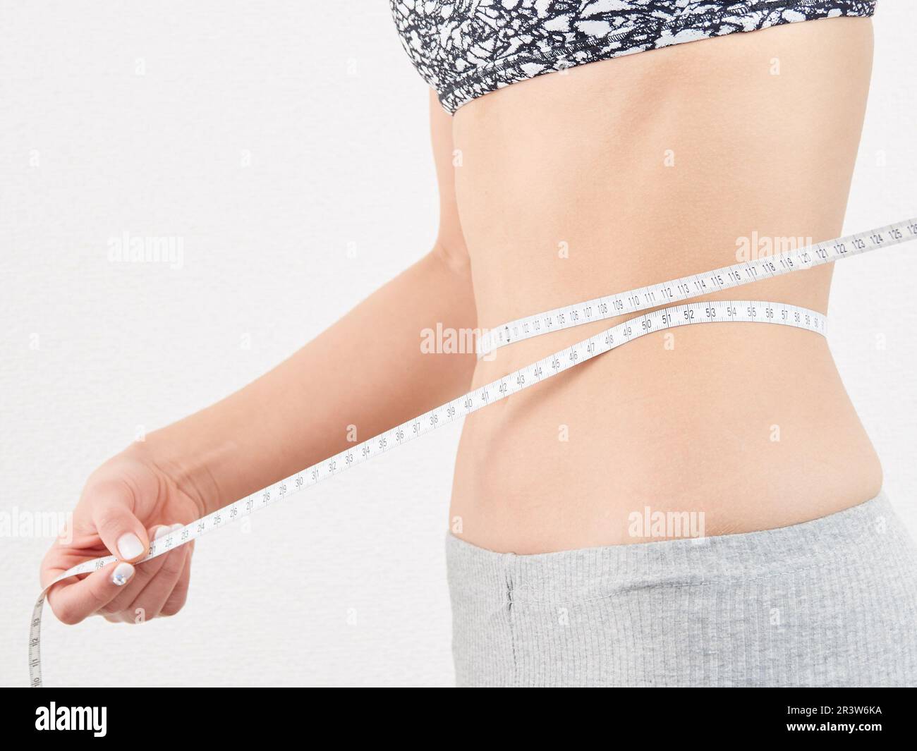 Asian woman measuring waist size Stock Photo