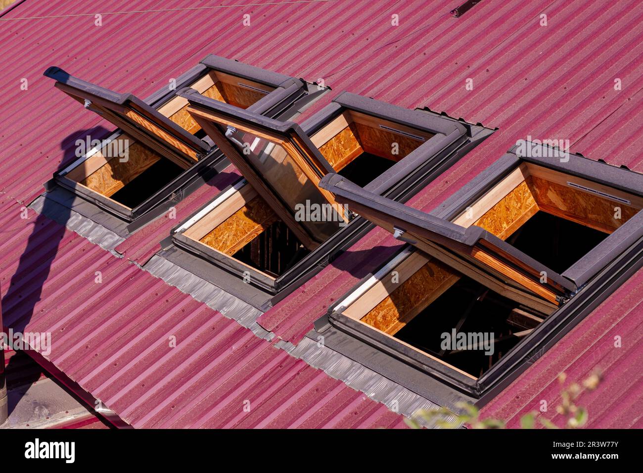 Opened roof windows. Skylight on red ceramic house tiles. Skylights windows, sun tunnels