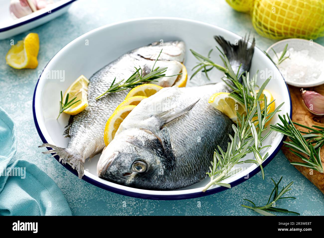 Fresh raw dorado fish cooking with lemon and rosemary. Sea bream, dorado. Seafood, healthy food Stock Photo
