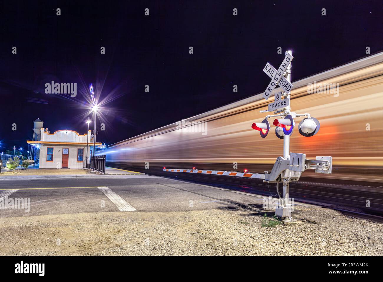Railroad crossing by night with sign in kingman Stock Photo