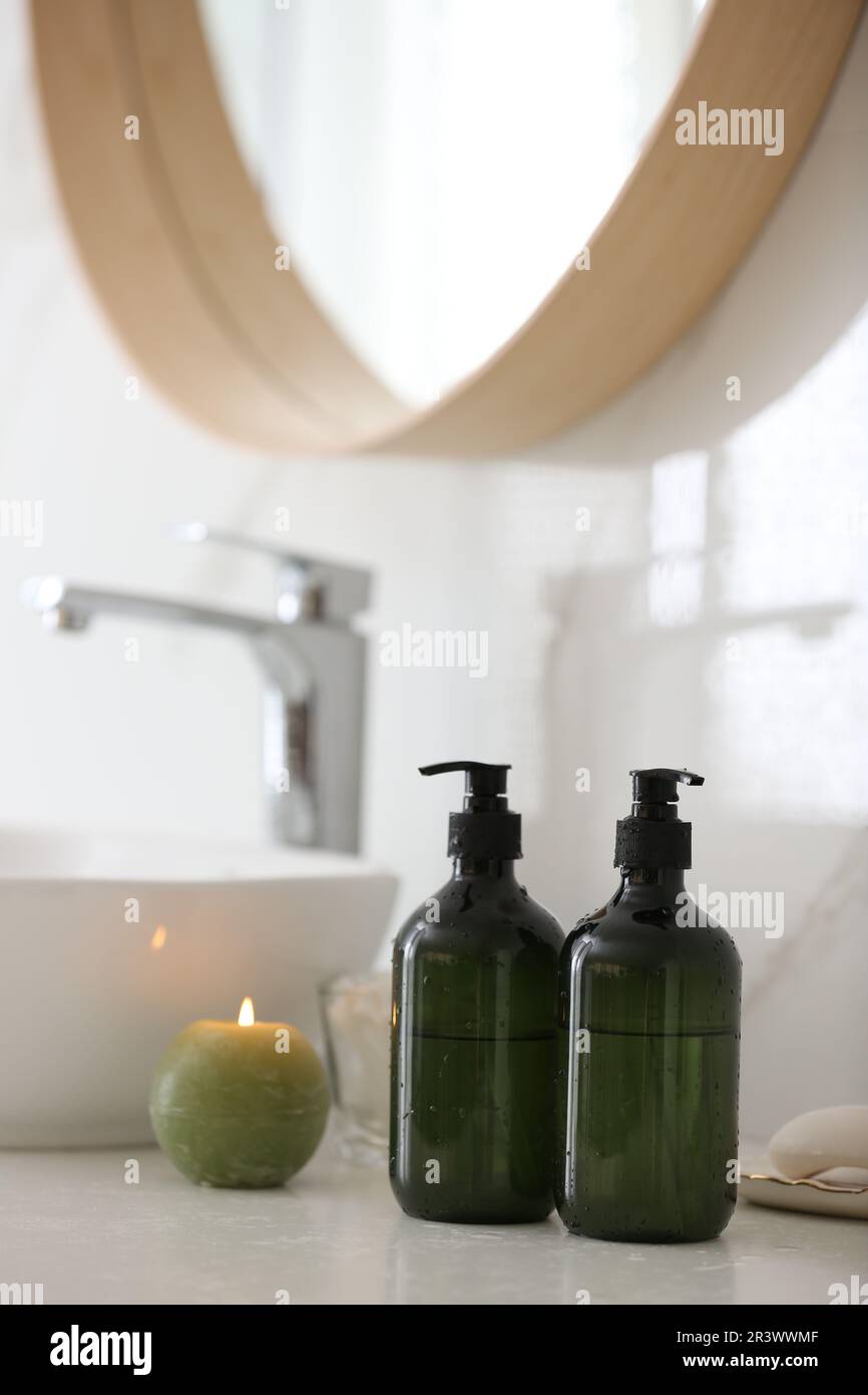 Green soap dispensers on countertop near sink in bathroom Stock Photo