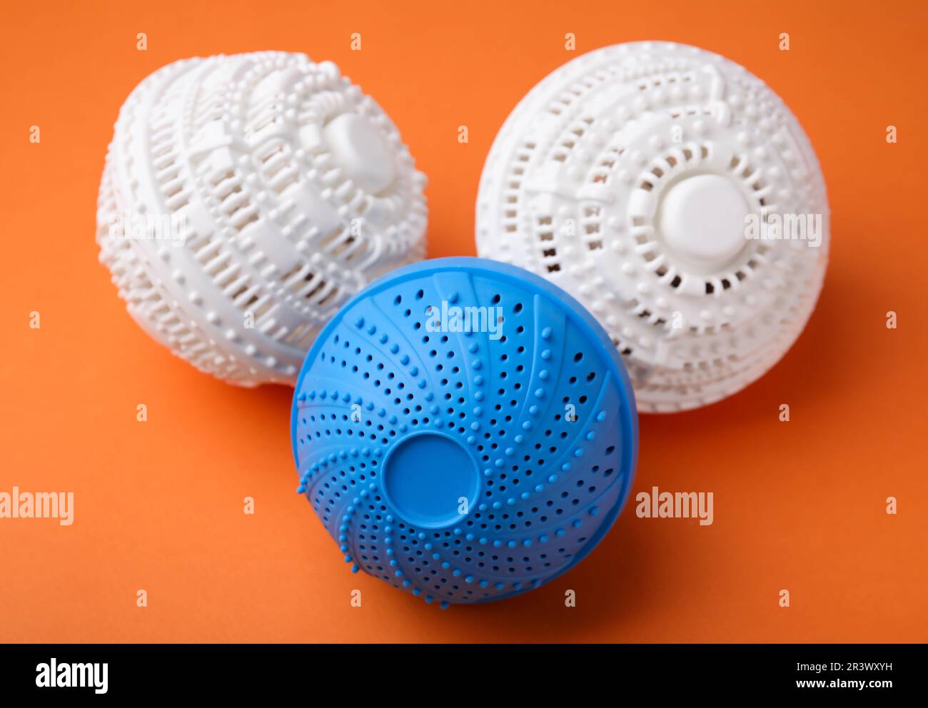 Dryer balls for washing machine on orange background. Laundry detergent