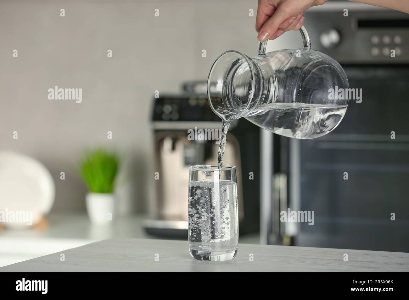 Pour water from a pitcher into a glass Stock Photo - Alamy