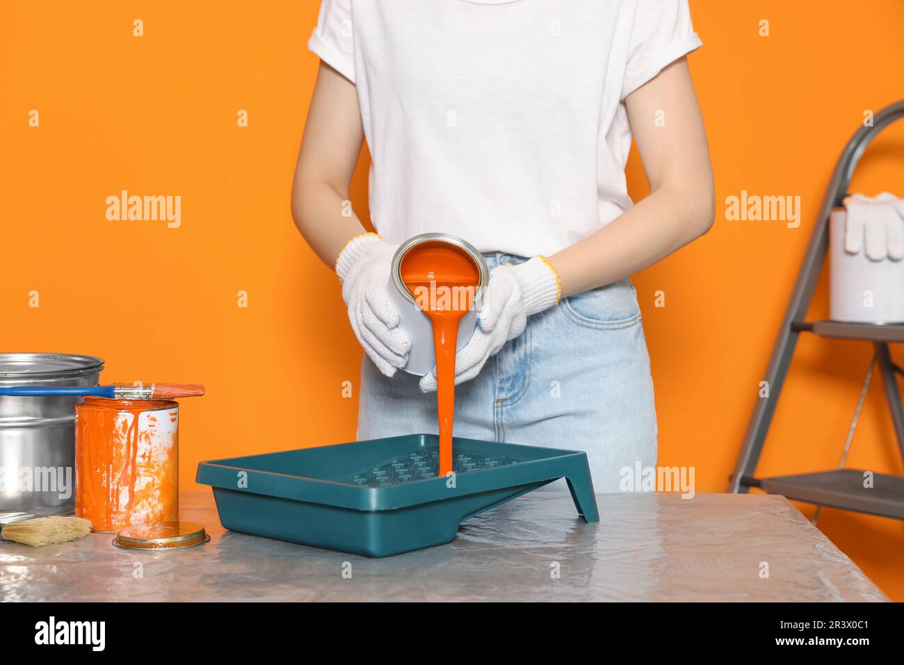 Close-up of woman applying white paint … – License image