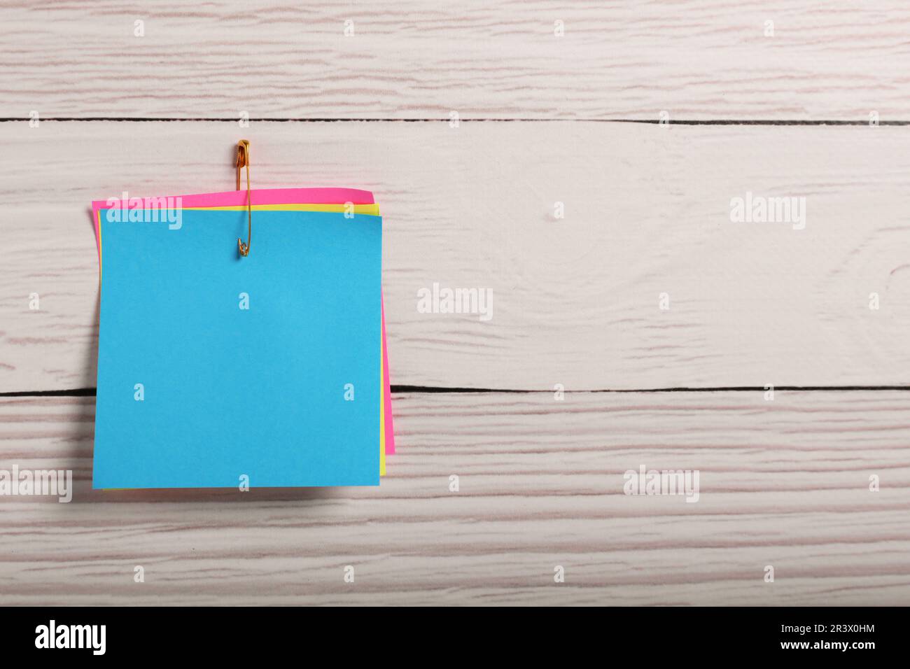 Notes Attach Pin Paper notes attached with safety pin to white wooden background, top ...
