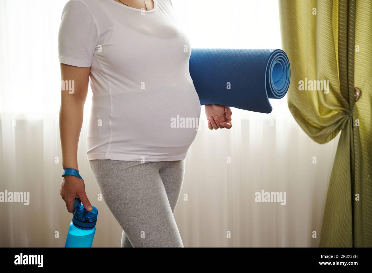 Belly of pregnant woman in late pregnancy, in white mockup tshirt