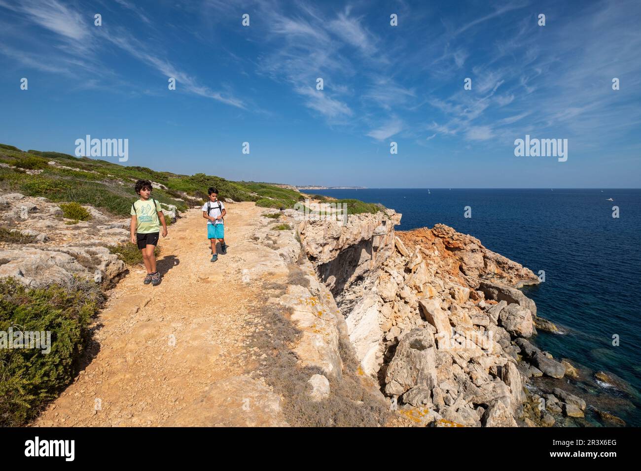 niños andando junto a un acantilado, Caló des Marmols, Santany, Mallorca, balearic islands, Spain. Stock Photo