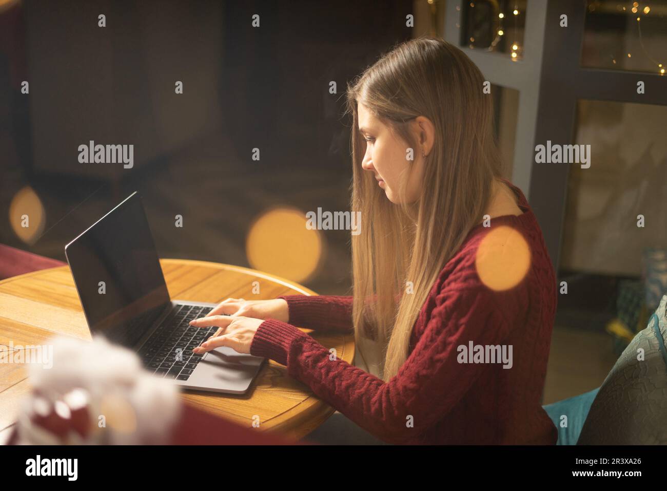 Young woman browsing the Internet at the cafe in the evening Stock Photo