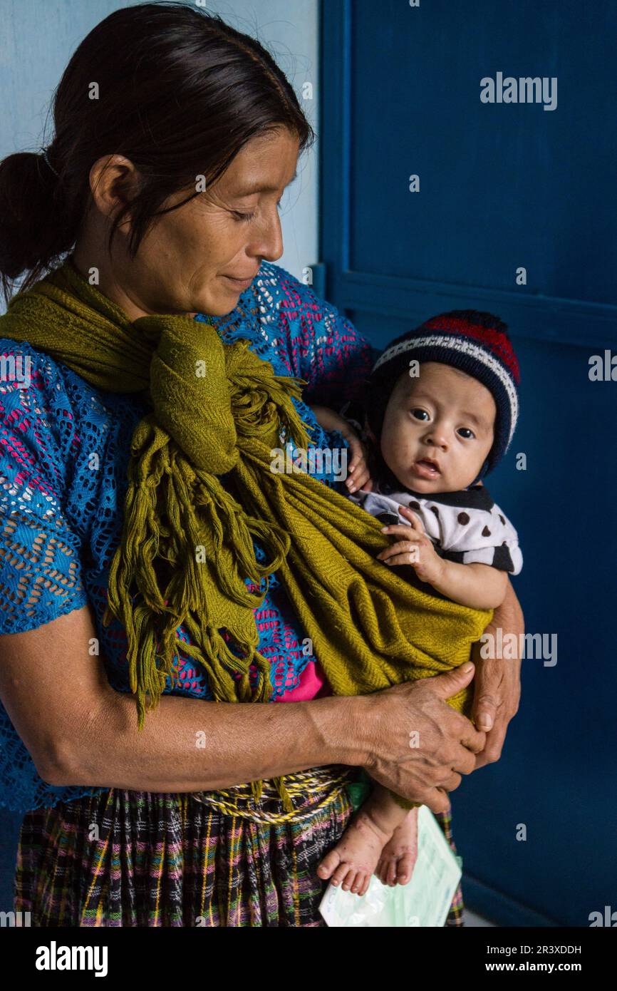 madre indigena con su bebe, centro de salud, Lancetillo ( La Parroquia), municipio de Uspantán, Quiche , sierra de Chamá, Guatemala, Central America. Stock Photo