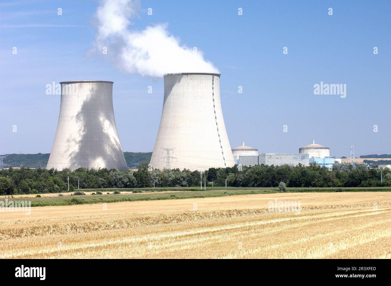 Farming near the EDF power plant of Nogent-sur-Seine (central northern France): newly harvested field and cooling tower. Stubble field Stock Photo