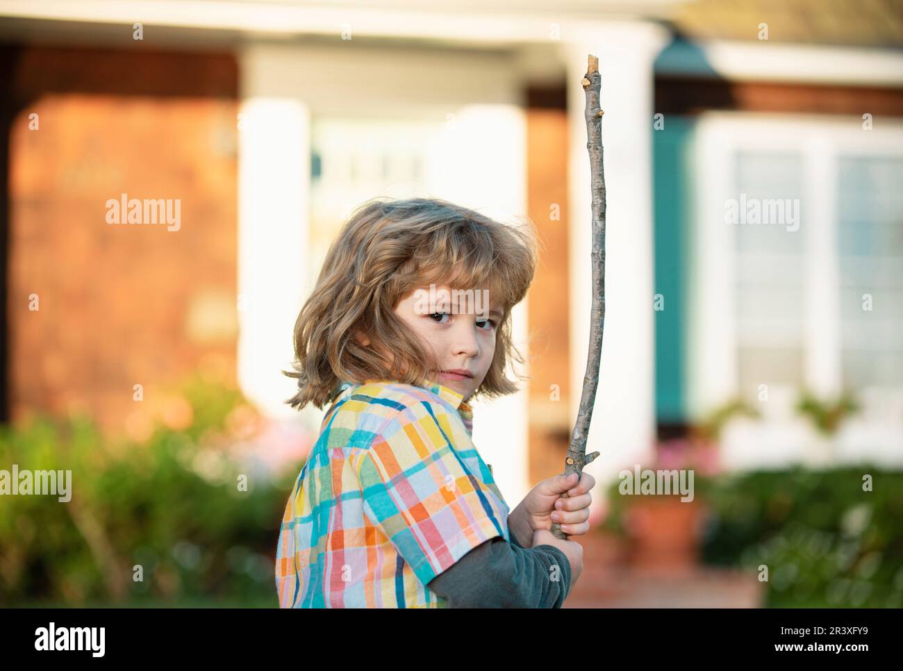 Child aggression concept. Negative kids emotion. Angry boy with stick
