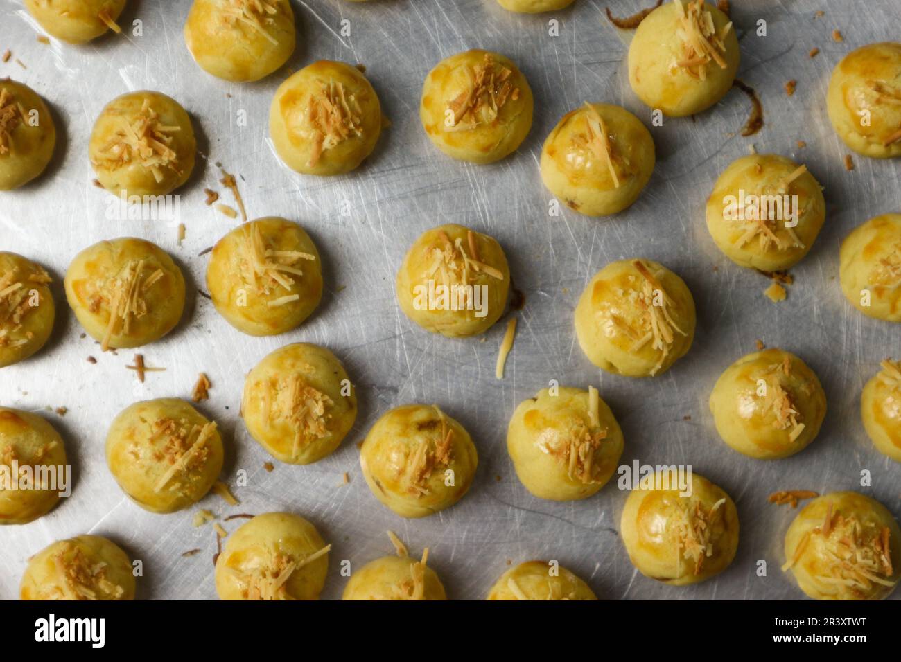 Nastar Keju. Homemade Pineapple Tart or Nastar Keju, cookies with pineapple jam filled and spread grated cheese on the aluminium pan, fresh from the o Stock Photo