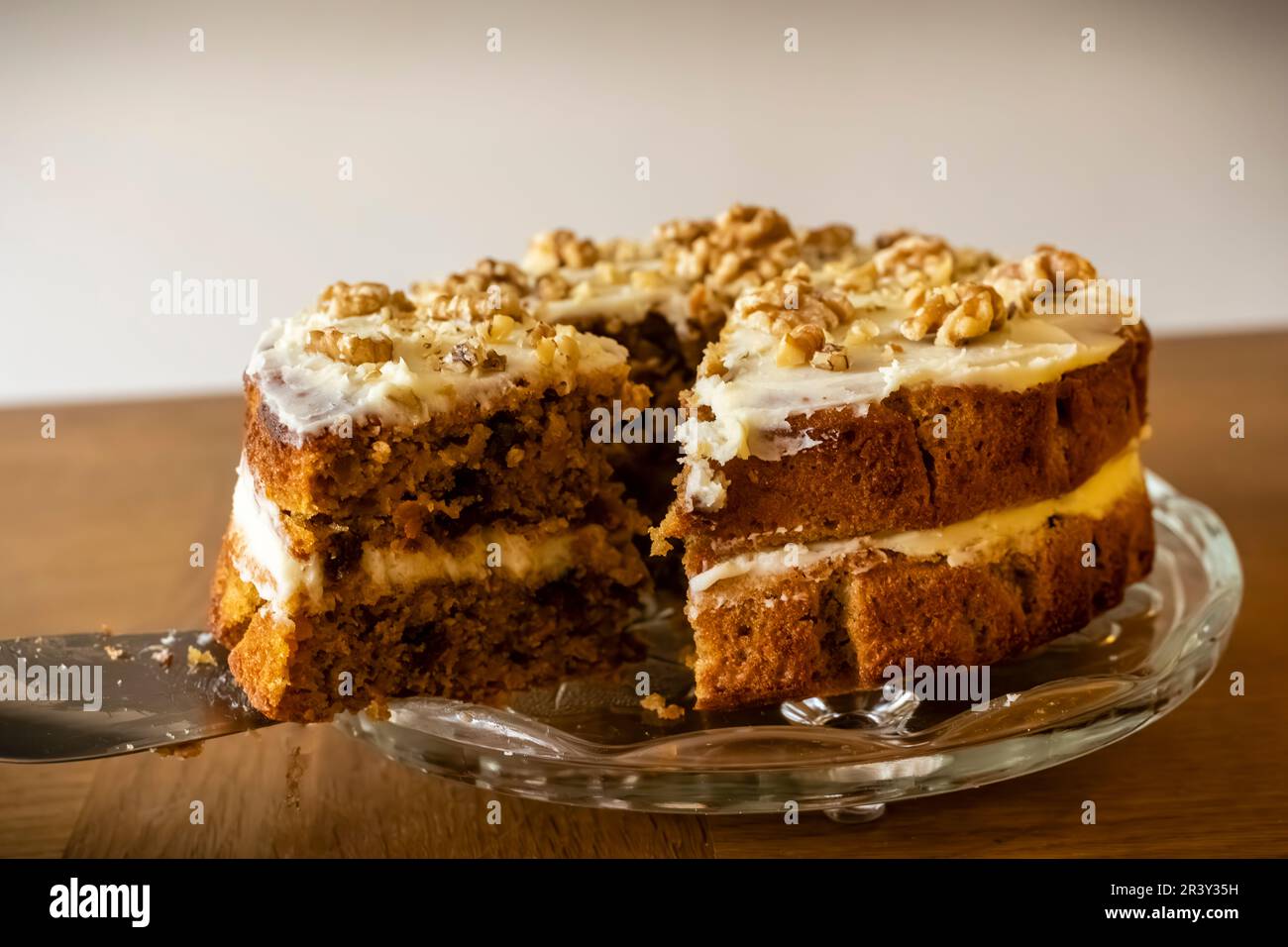 A delicious Carrot and Walnut Cake being cut, home-made baker. Stock Photo