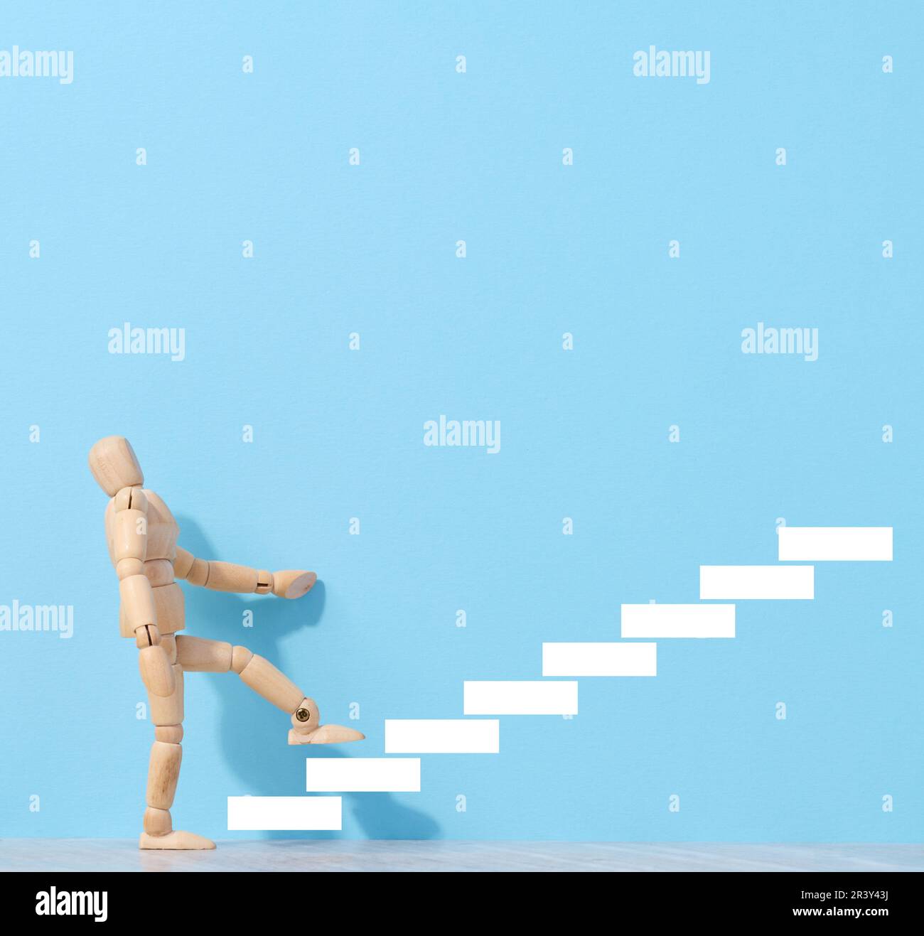 A wooden mannequin and drawn steps going up, a concept of achieving a goal, strong personality Stock Photo