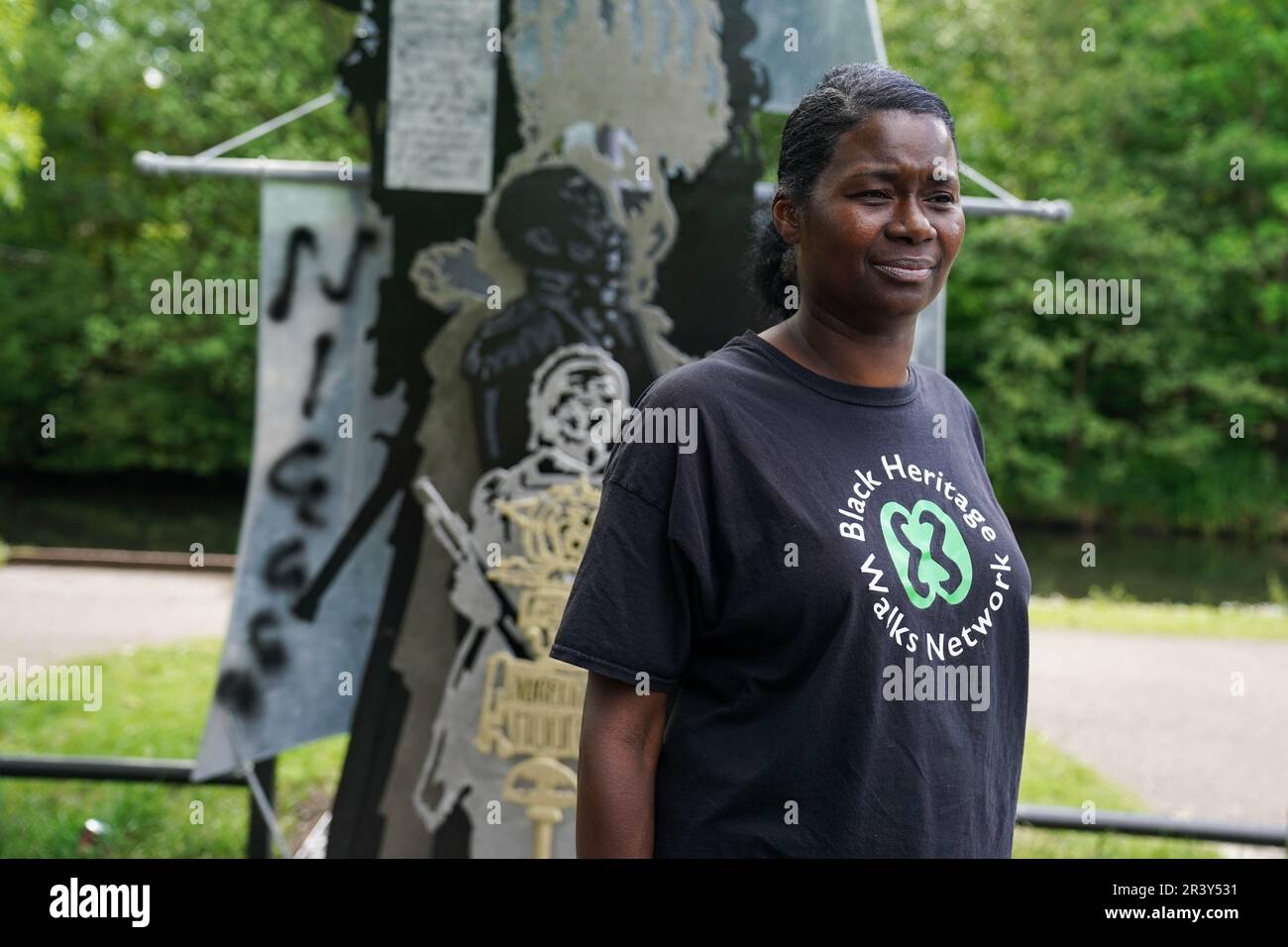 NOTE: LANGUAGE ON SCULPTURE Marcia Dunkley from the Black Heritage Walks Network stands by racial slur graffiti on Luke Perry's sculpture, Black British History is British History, by the Soho Loop Canal in Winson Green, Birmingham after it was vandalised. Picture date: Thursday May 25, 2023. Stock Photo