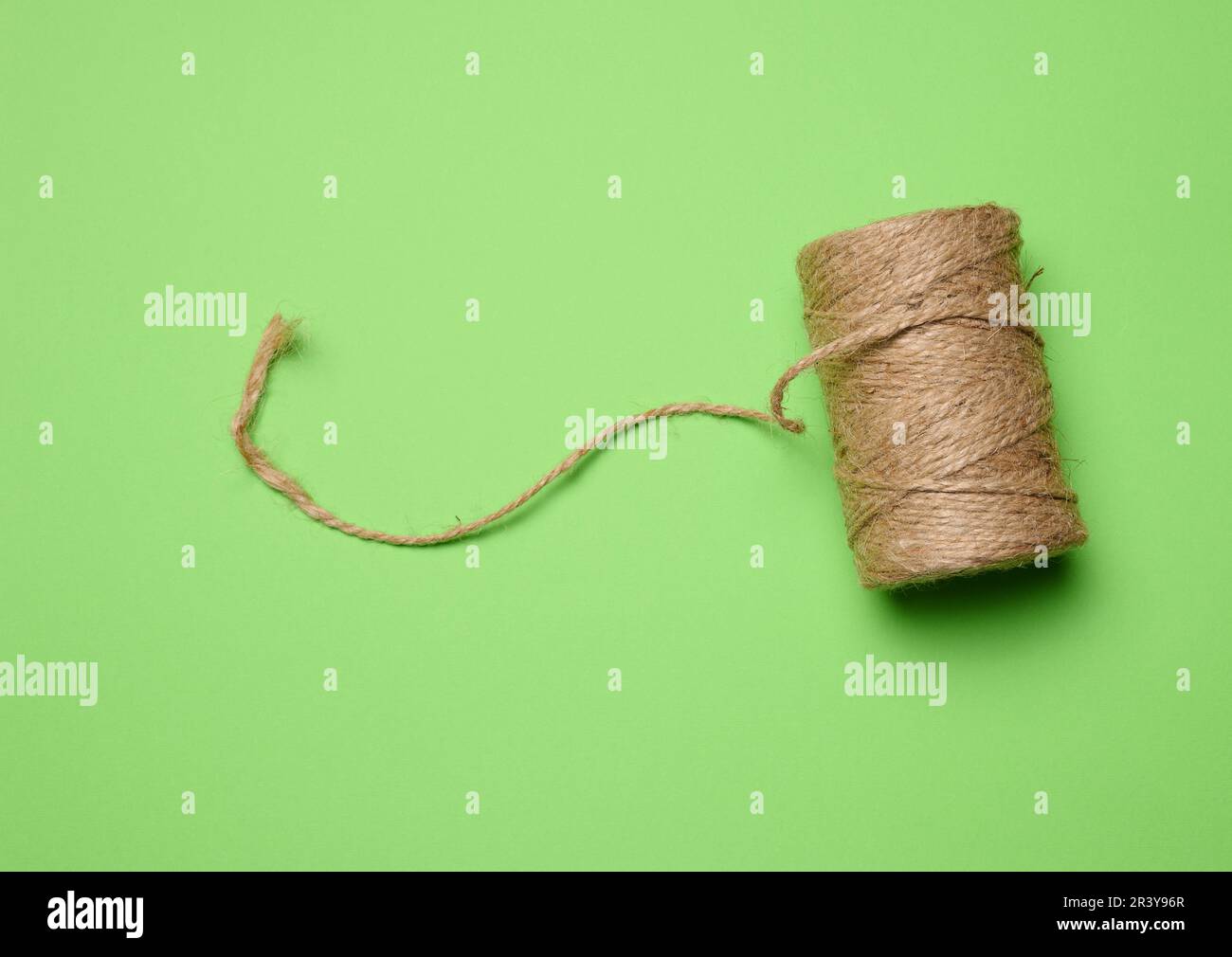 Spool of green thread and needle Stock Photo - Alamy