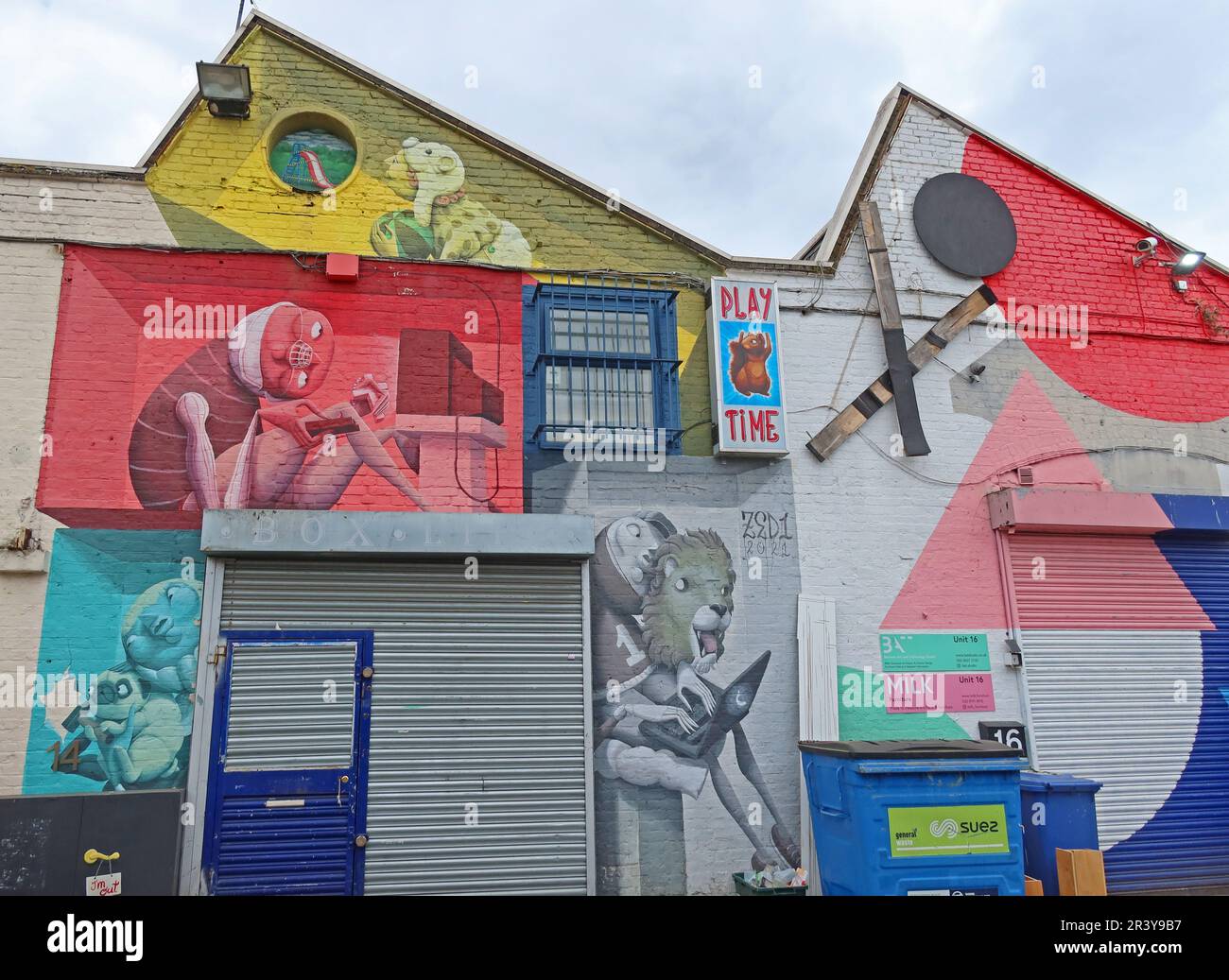 Large colourful street art mural covering the exterior of BAT Studio in Walthamstow, East London, featuring illustrated figures and playful surreal Stock Photo