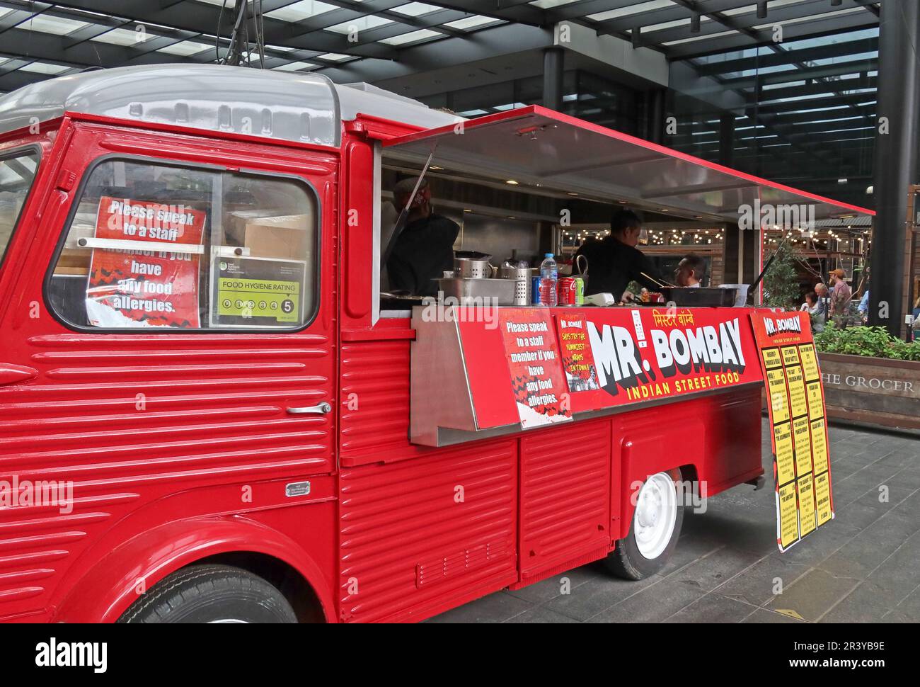 Mr Bombay Indian street food van trading at Old Spitalfields Market in East London, serving takeaway food from a bright red mobile catering vehicle Stock Photo