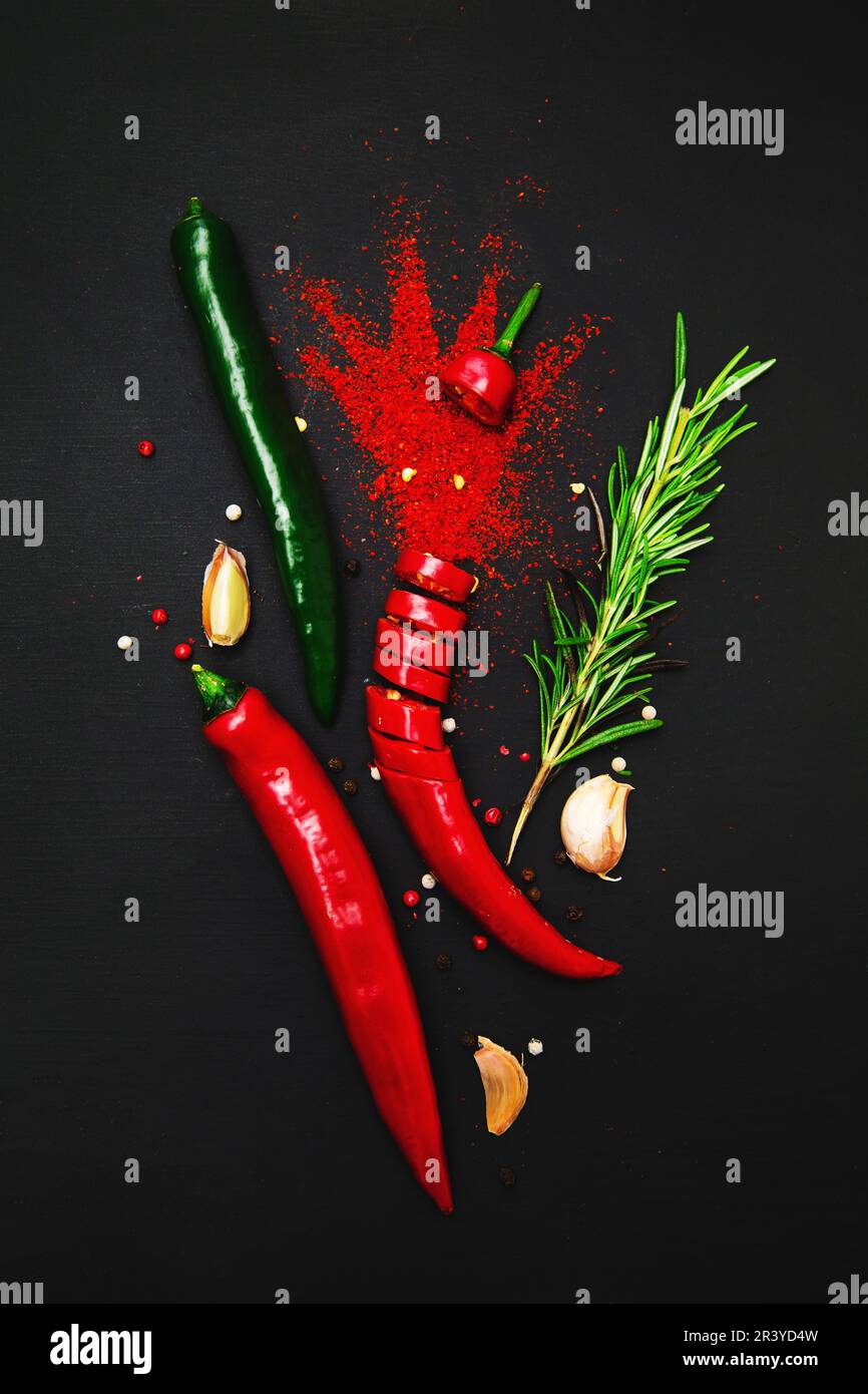 Exploding Mini Garlic Paprika, exploding chili peppers, garlic and rosemary on a dark ...