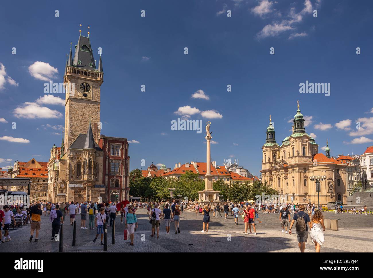 OLD TOWN SQUARE, PRAGUE, CZECH REPUBLIC - Tourists and Clock Tower, left, Matian Column, and Church of St. Nicholas at right. Stock Photo