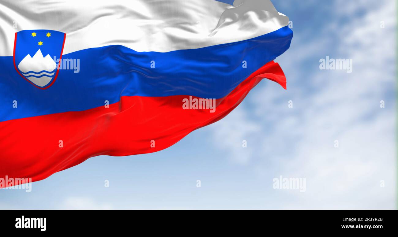 Slovenia national flag waving in the wind on a clear day. Three equal horizontal bands of white, blue, and red, with coat of arms in the upper hoist. Stock Photo
