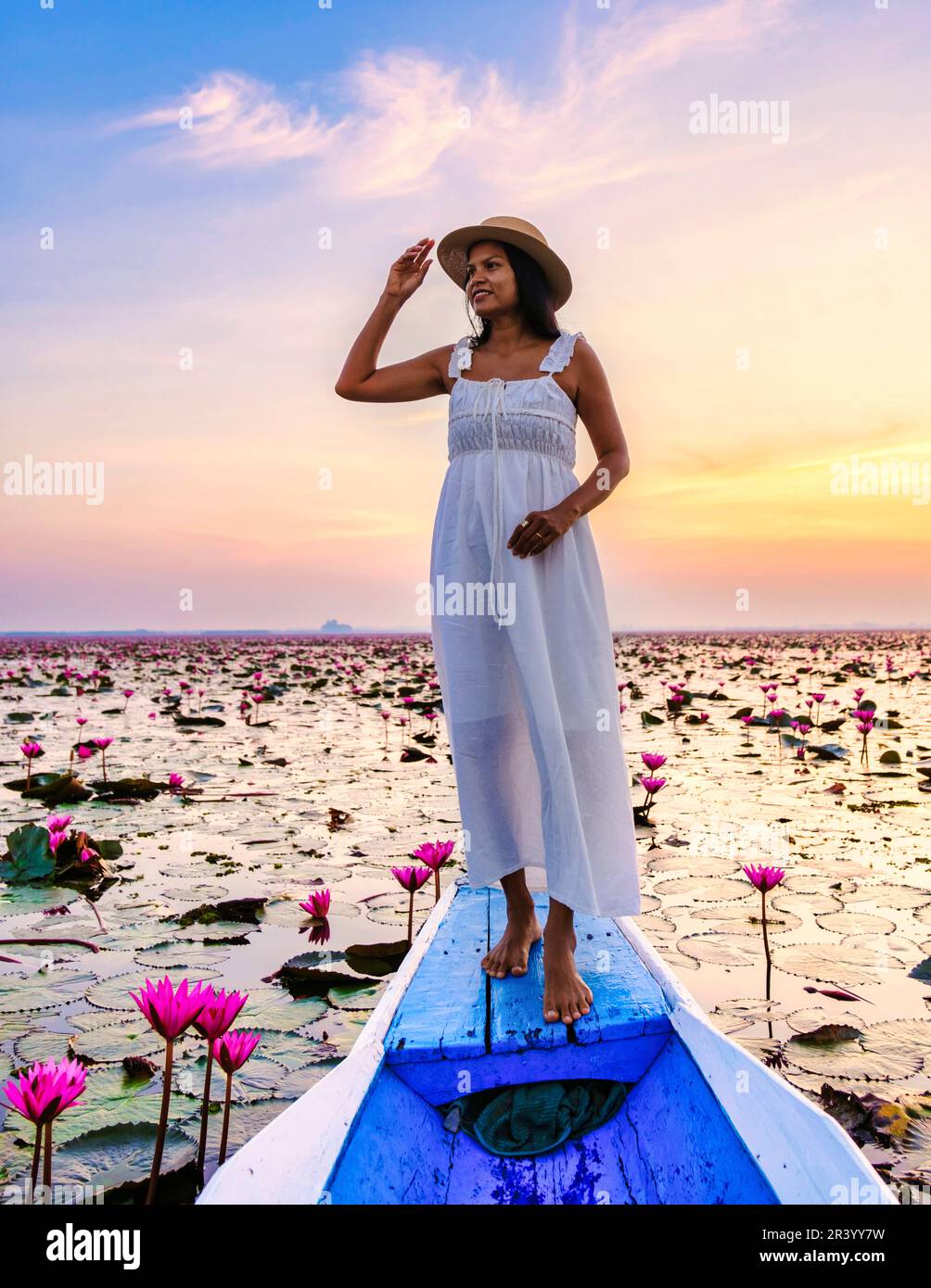 Asian women in a boat at the Red Lotus Sea Kumphawapi full of pink flowers in Udon Thani Thailand. Stock Photo