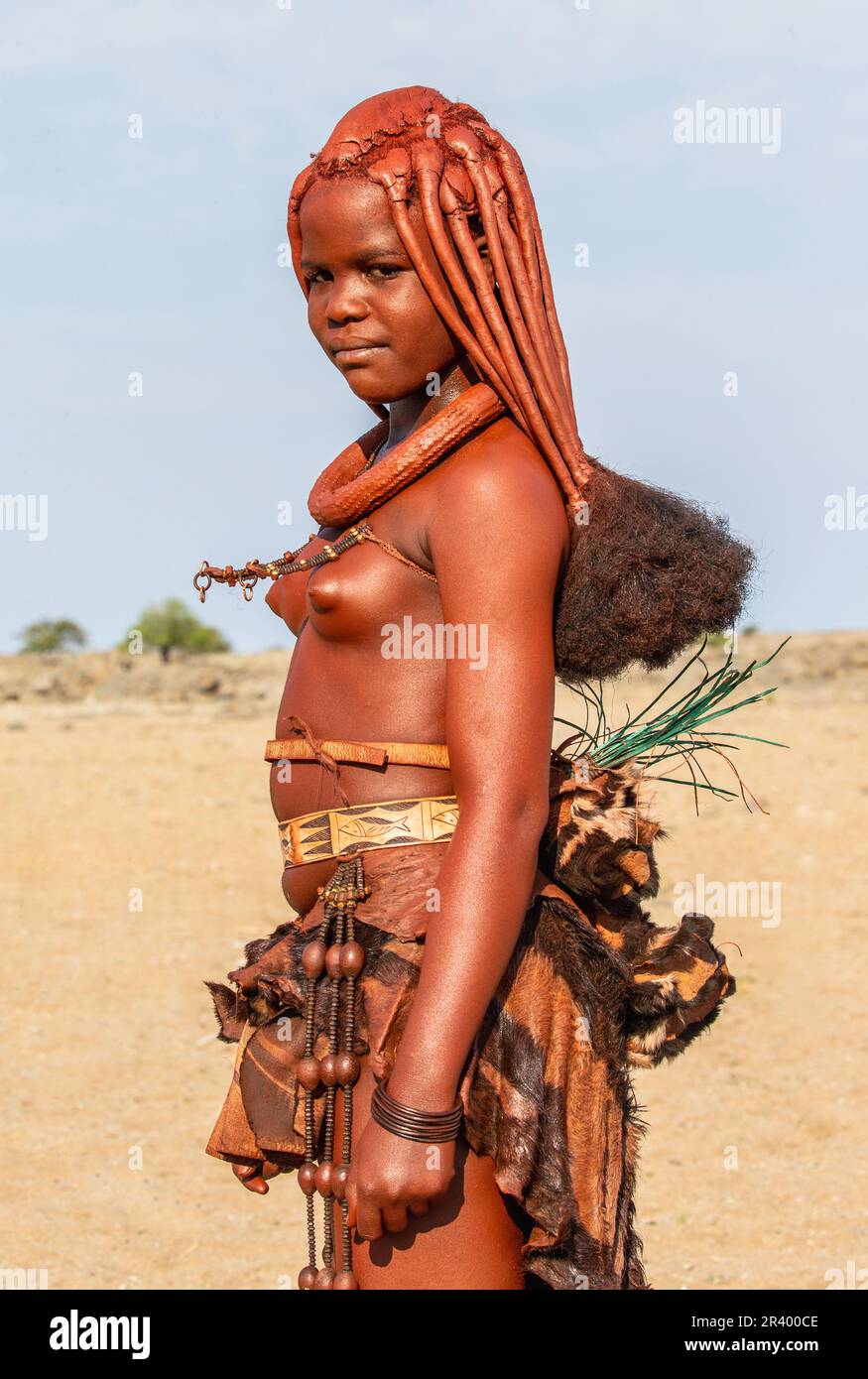 Portrait of a young woman of the Himba tribe with a traditional hairstyle. Stock Photo