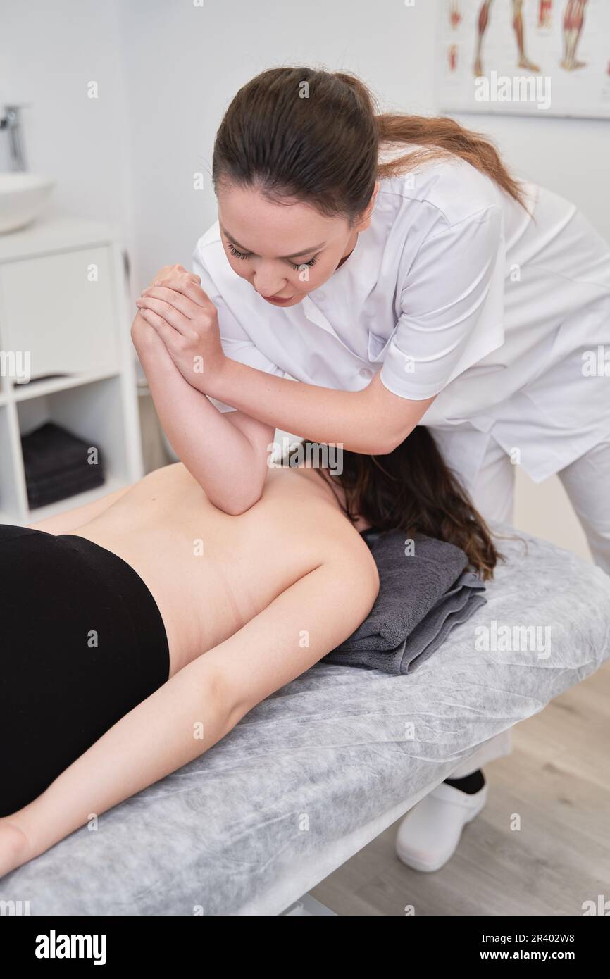 Two women therapist and patient having massage session massaging back at beauty center. High quality photo Stock Photo