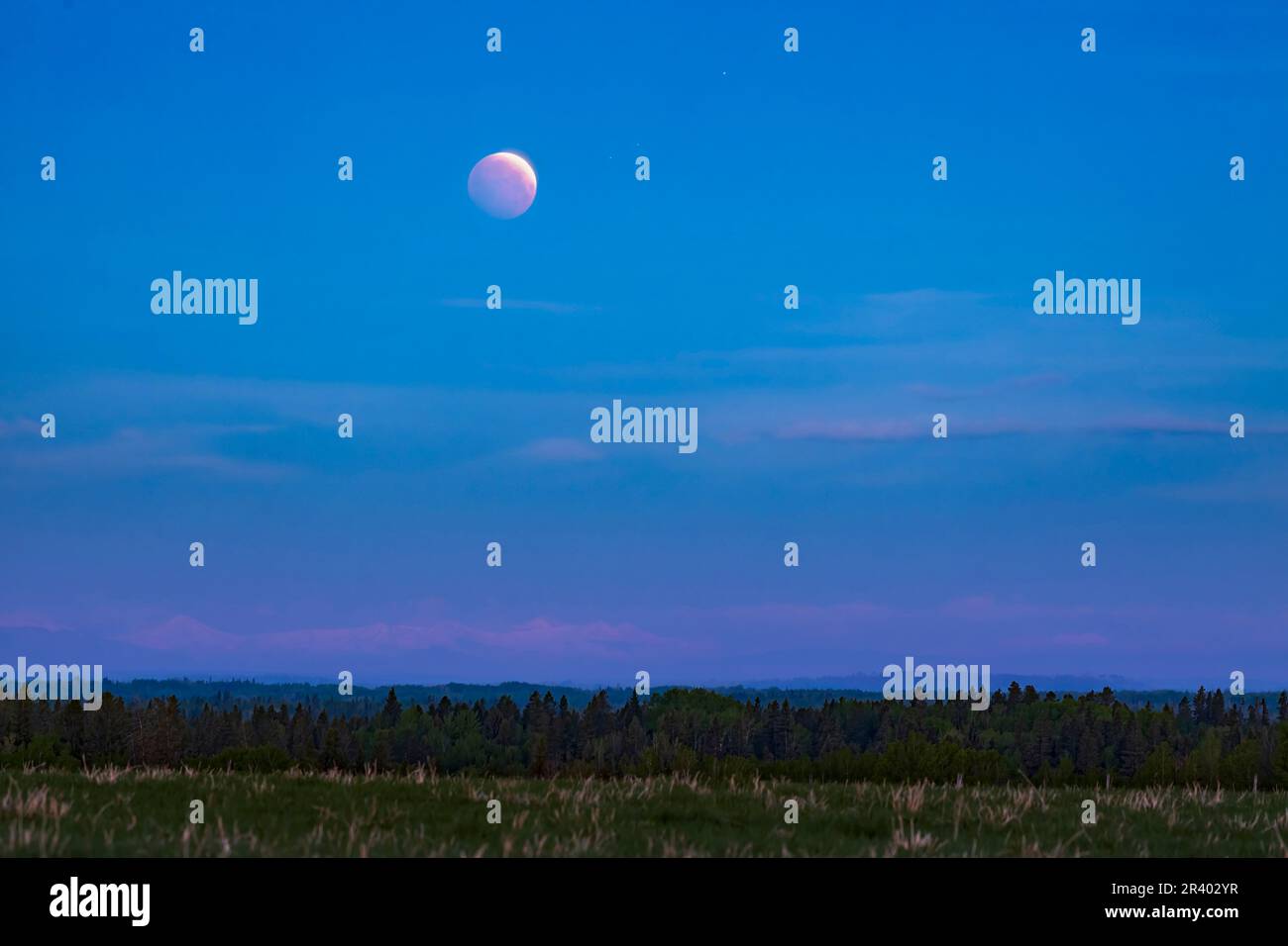The total lunar eclipse of May 26, 2021, with a thin arc of the full moon visible at top. Stock Photo