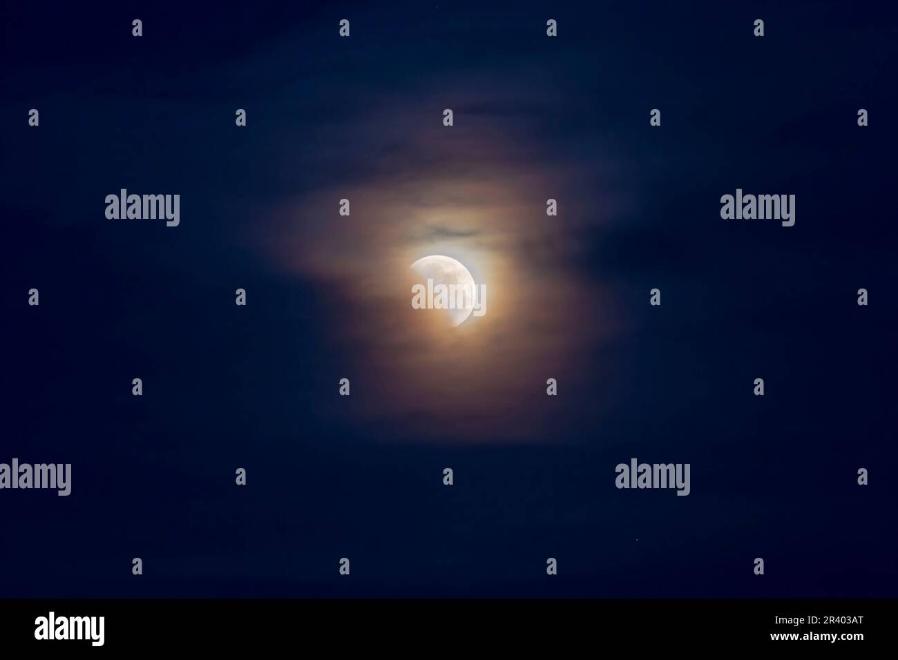 May 26, 2021 - Partial lunar eclipse in clouds. Stock Photo