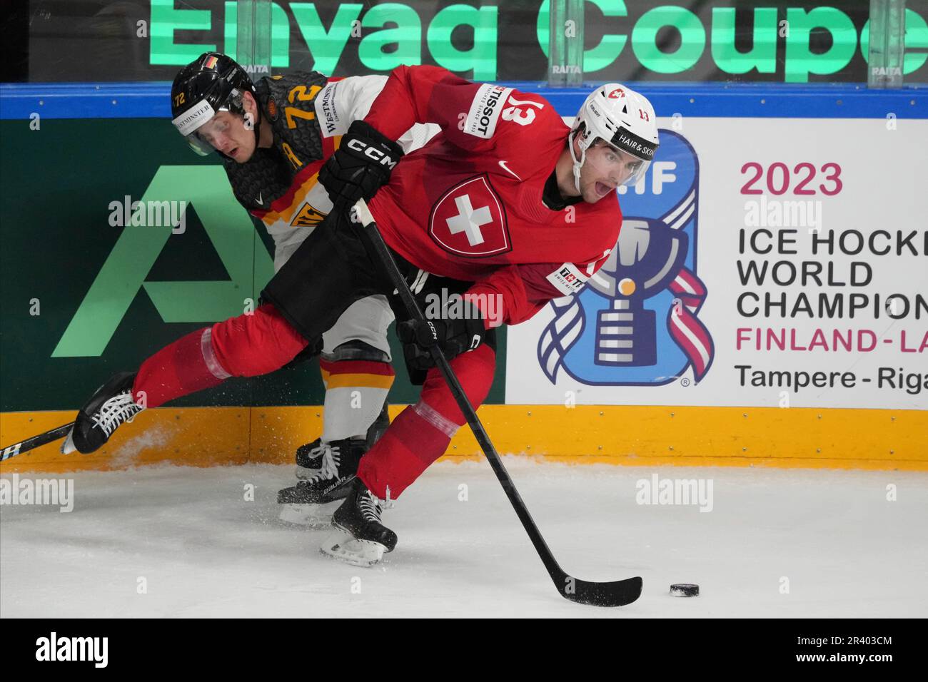 Nico Hischier of Switzerland, left, fights for a puck with goalie Samuel  Montembeault of Canada during the group B match between Switzerland and  Canada at the ice hockey world championship in Riga